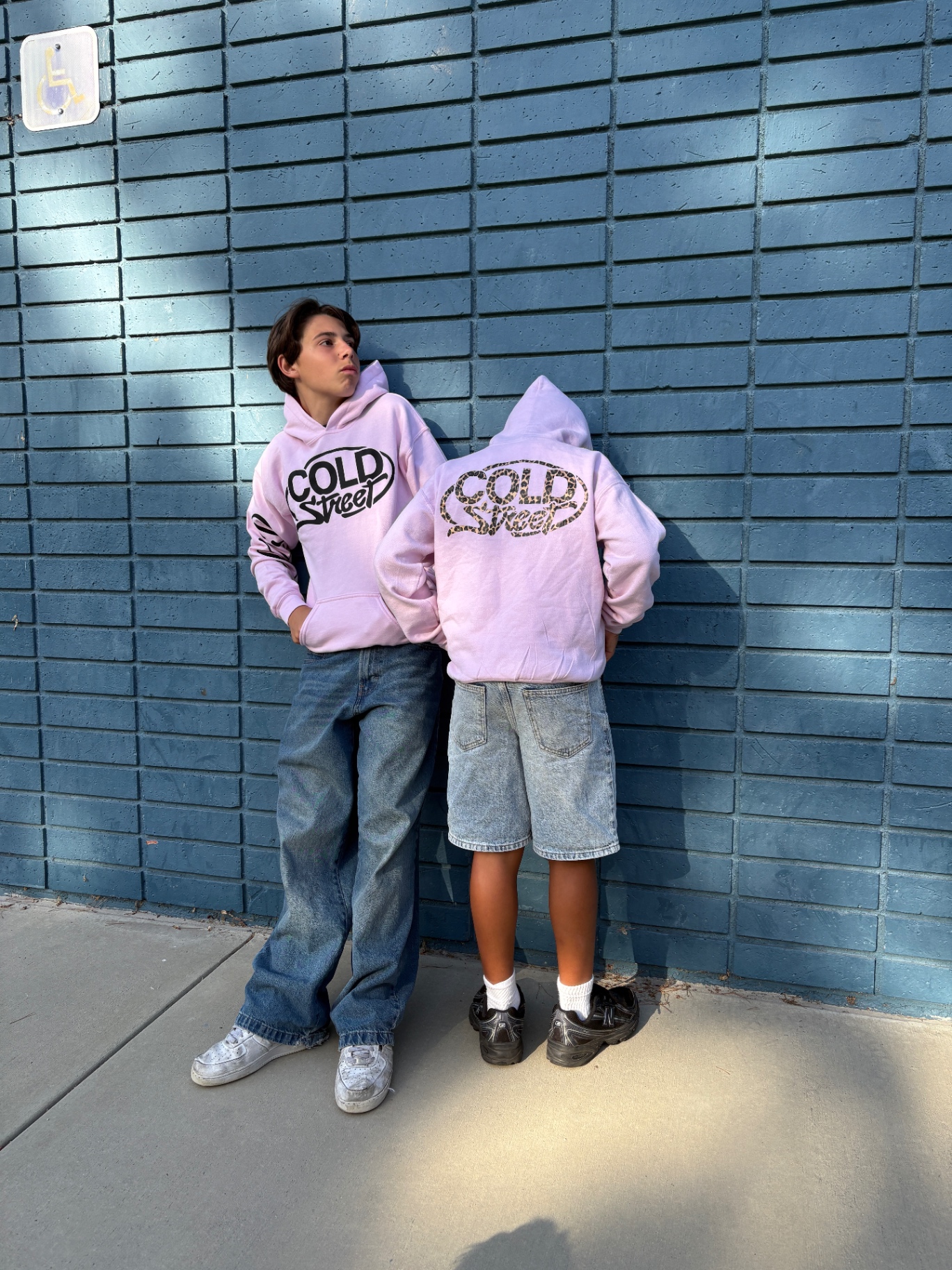 Two models wearing COLD STREET Drop 001 tees on the street